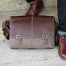 a man standing next to side view of Boconi Double Buckle canvas and leather laptop messenger bag 