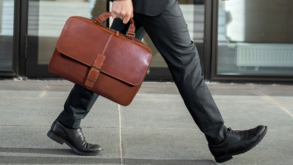 Man walking with a handcrafted leather briefcase in hand